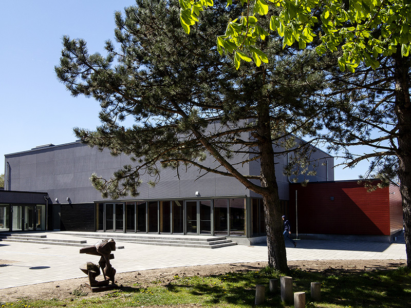Bygning med stort træ i forgrunden