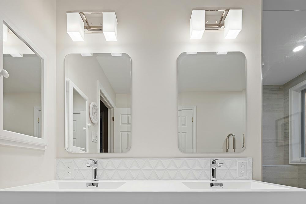 Modern double bathroom sink with rectangular mirrors and wall-mounted light fixtures above each mirror.