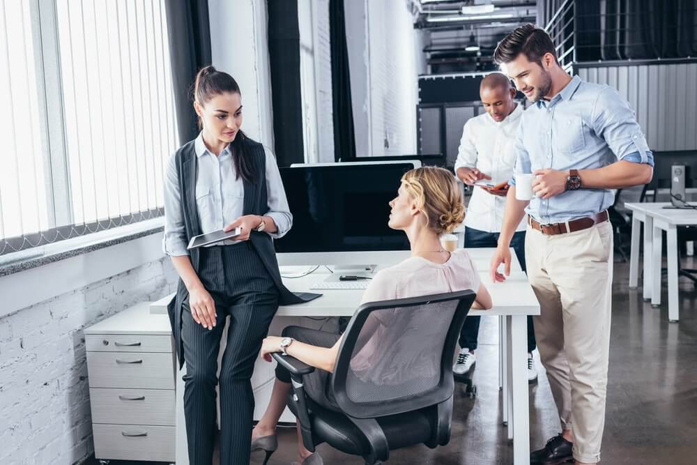 Facility manager debout dans un couloir de bureaux genevois, tablette à la main, inspectant visuellement les espaces communs, posture professionnelle, éclairage naturel.