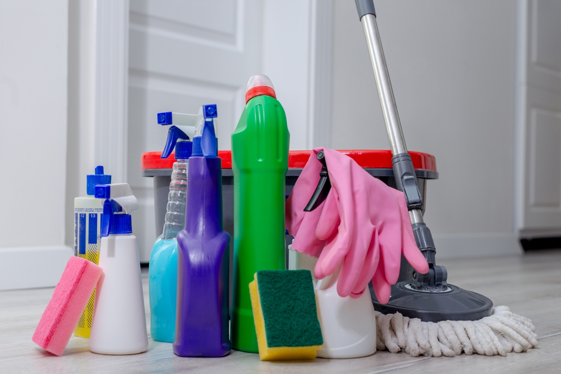 Gros plan sur des produits de désinfection professionnels alignés sur un chariot de nettoyage médical, étiquetés et rangés, ambiance technique et rigoureuse