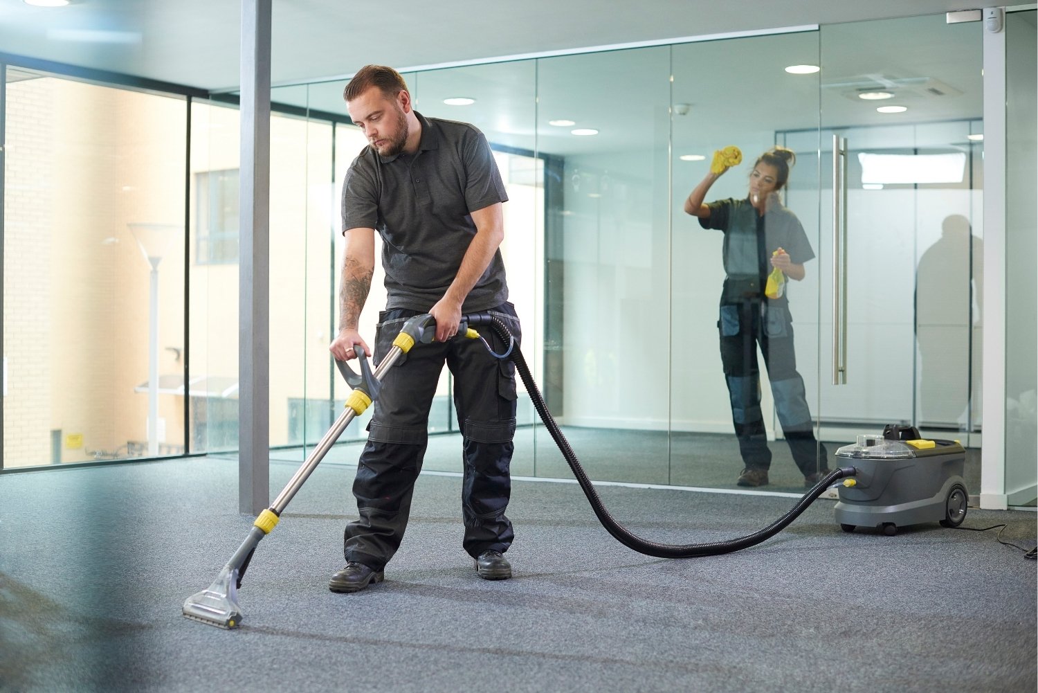 Équipe de nettoyage professionnel en action sur un chantier, autolaveuse et matériel spécialisé, sols brillants fraîchement traités, ambiance efficace et coordonnée.