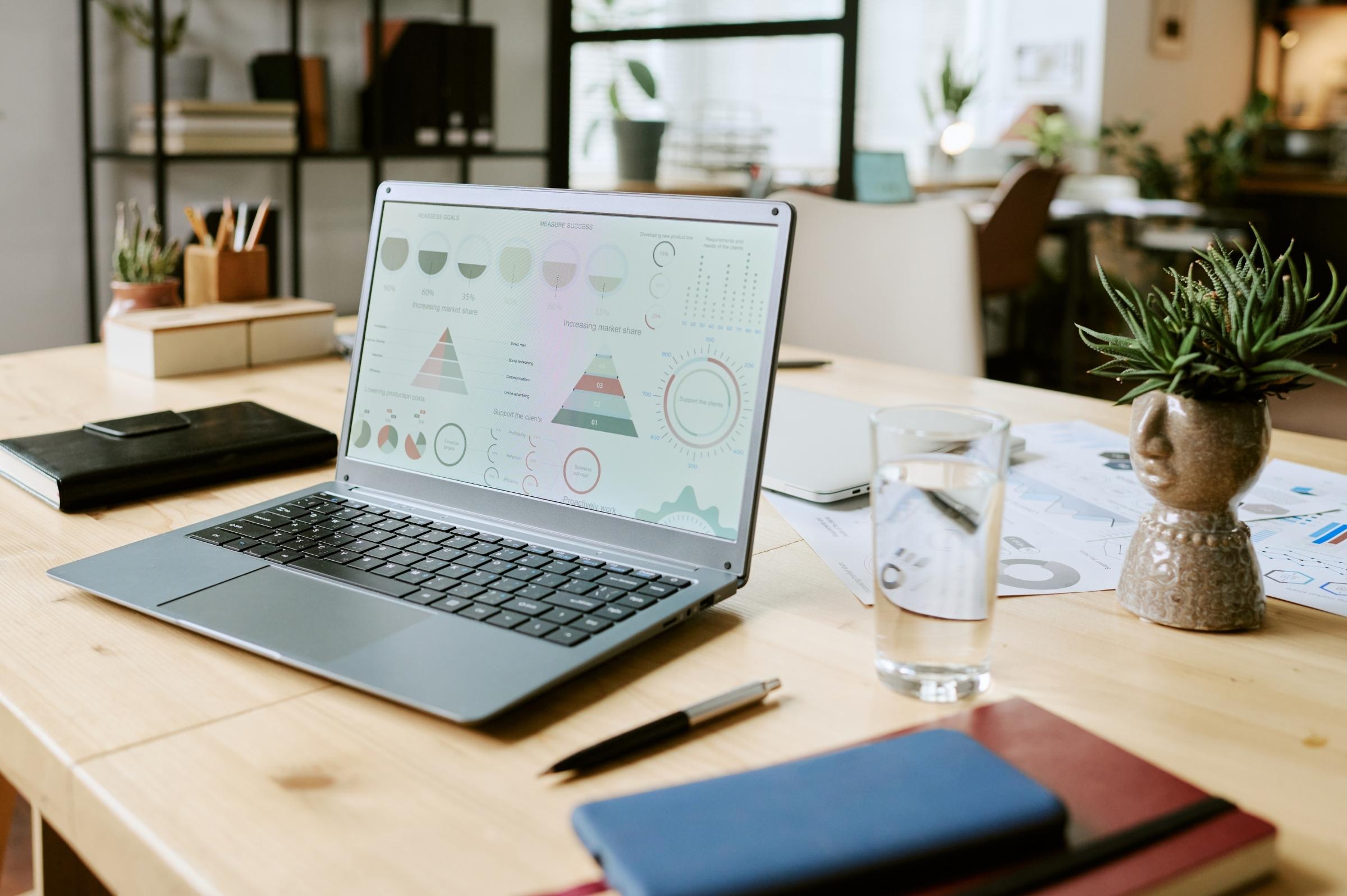 Tableau de bord ou reporting qualité sur écran d'ordinateur, graphiques de suivi propreté par site, ambiance bureau moderne, facility manager en arrière-plan flou.