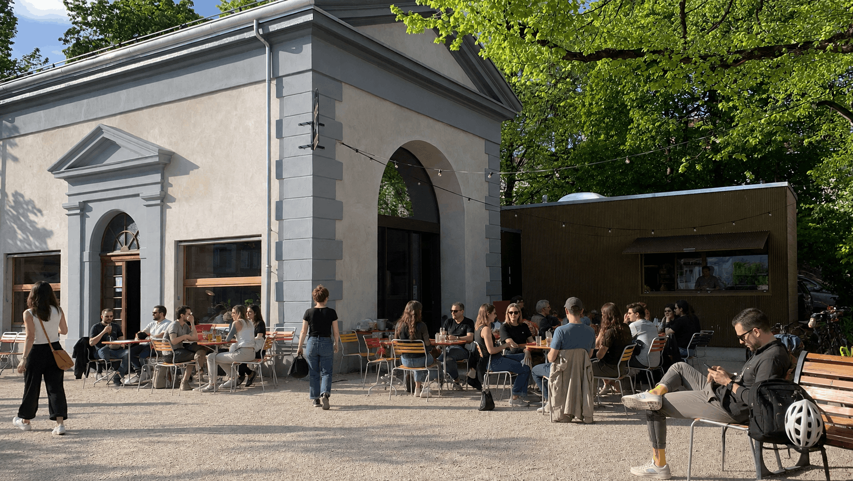 Vue d'une rue commerçante de Montreux en été : terrasses animées, boutiques ouvertes, Lac Léman visible en arrière-plan, vitrine propre et lumineuse au premier plan, ambiance touristique estivale.