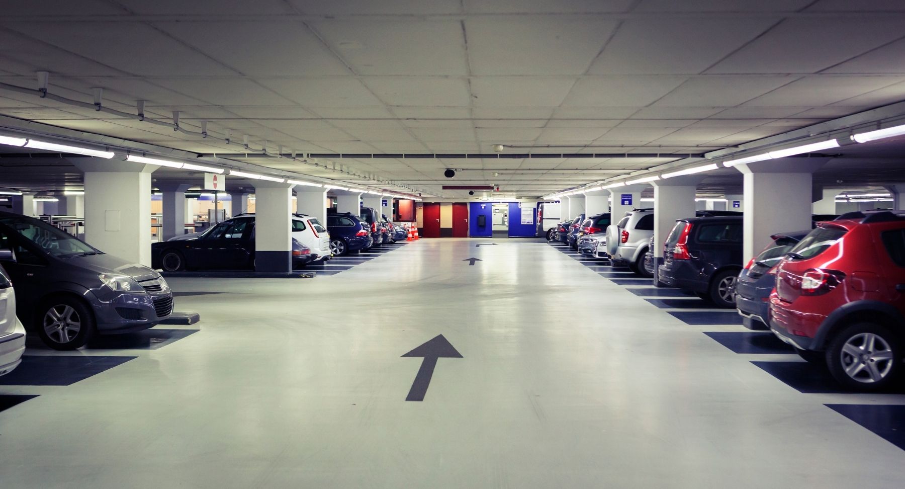 Parking souterrain d'immeuble à Montreux, sol en béton propre et sec, marquage au sol net et visible, éclairage clair, ambiance sécurisée et bien entretenue.