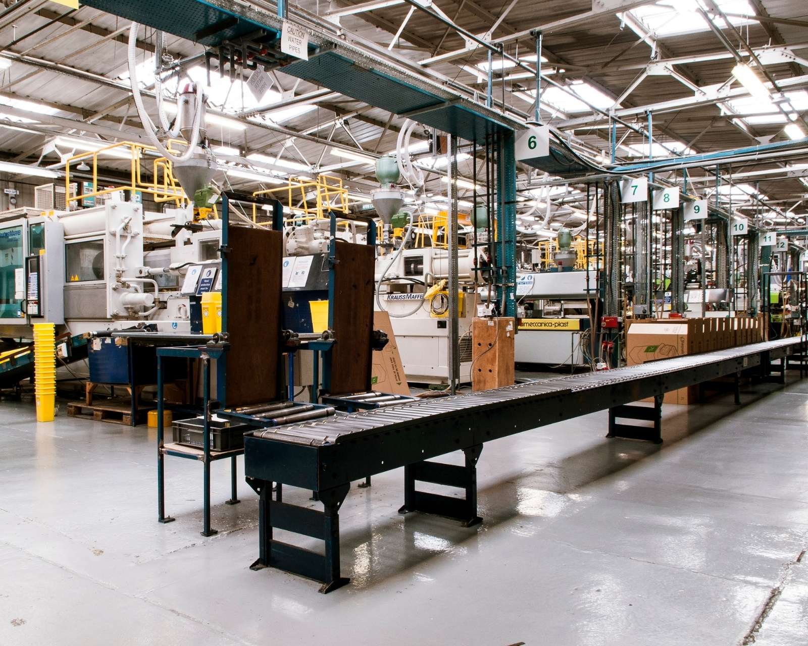 Atelier industriel propre et rangé avec sol en béton impeccable, machines alignées, zone de circulation dégagée, ambiance sobre et professionnelle.