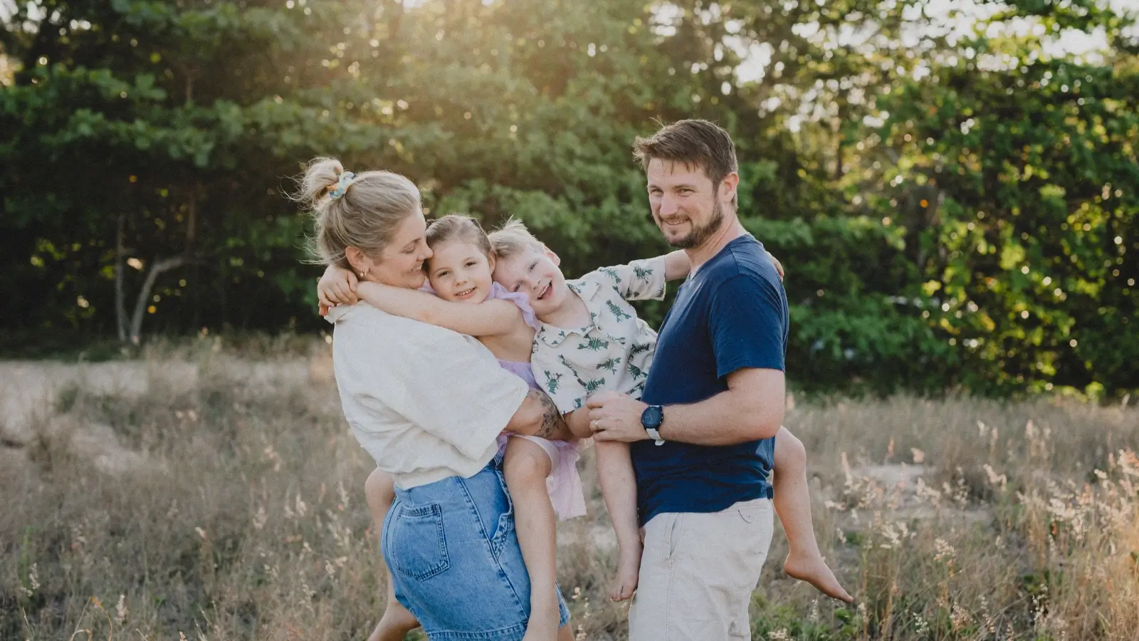 Photo of Caitlin and her husband with their two kids