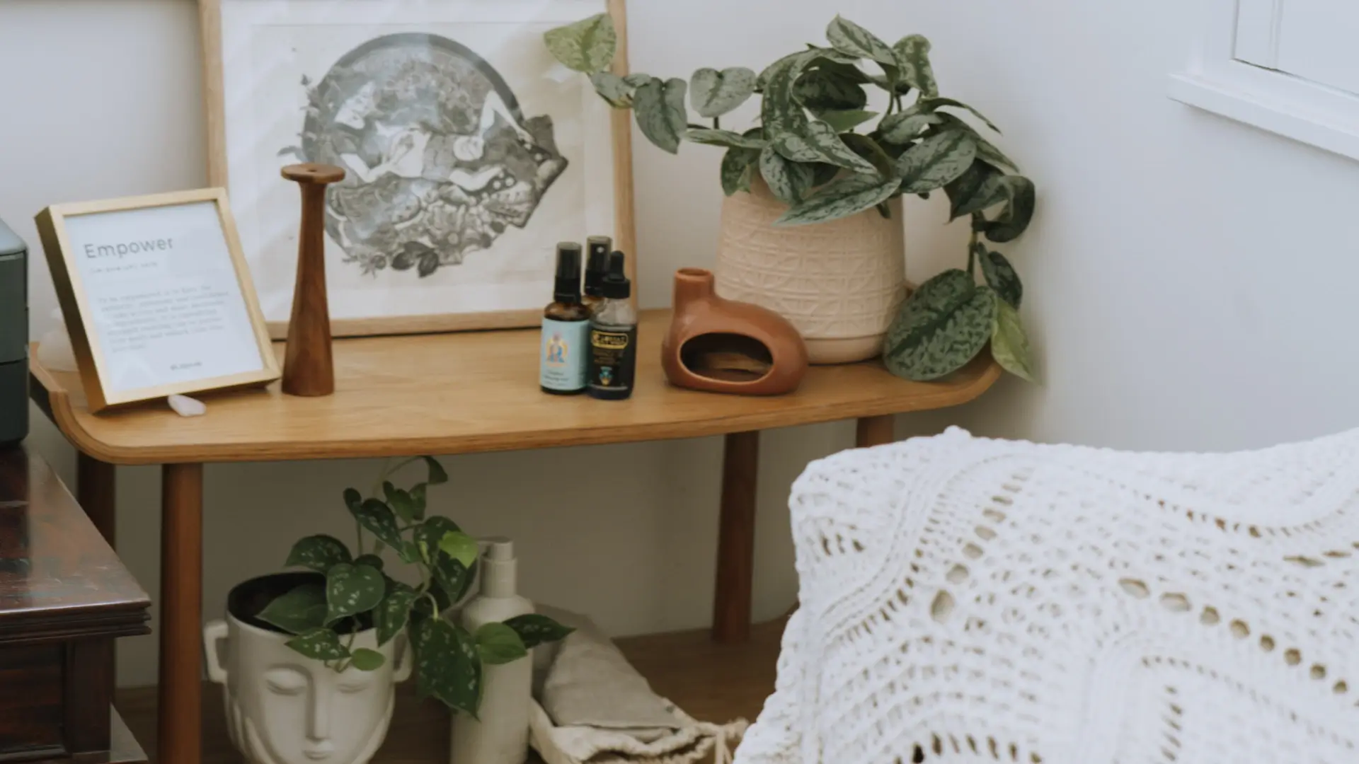 Photo of a collection of wellness products and plants on a wooden table in a midwife's clinic