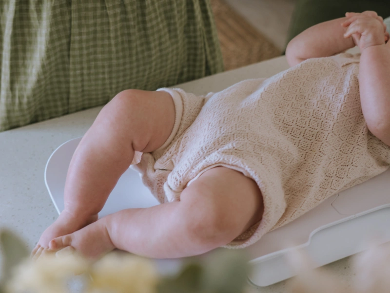 Photo of a baby lying down while having a checkup with a midwife