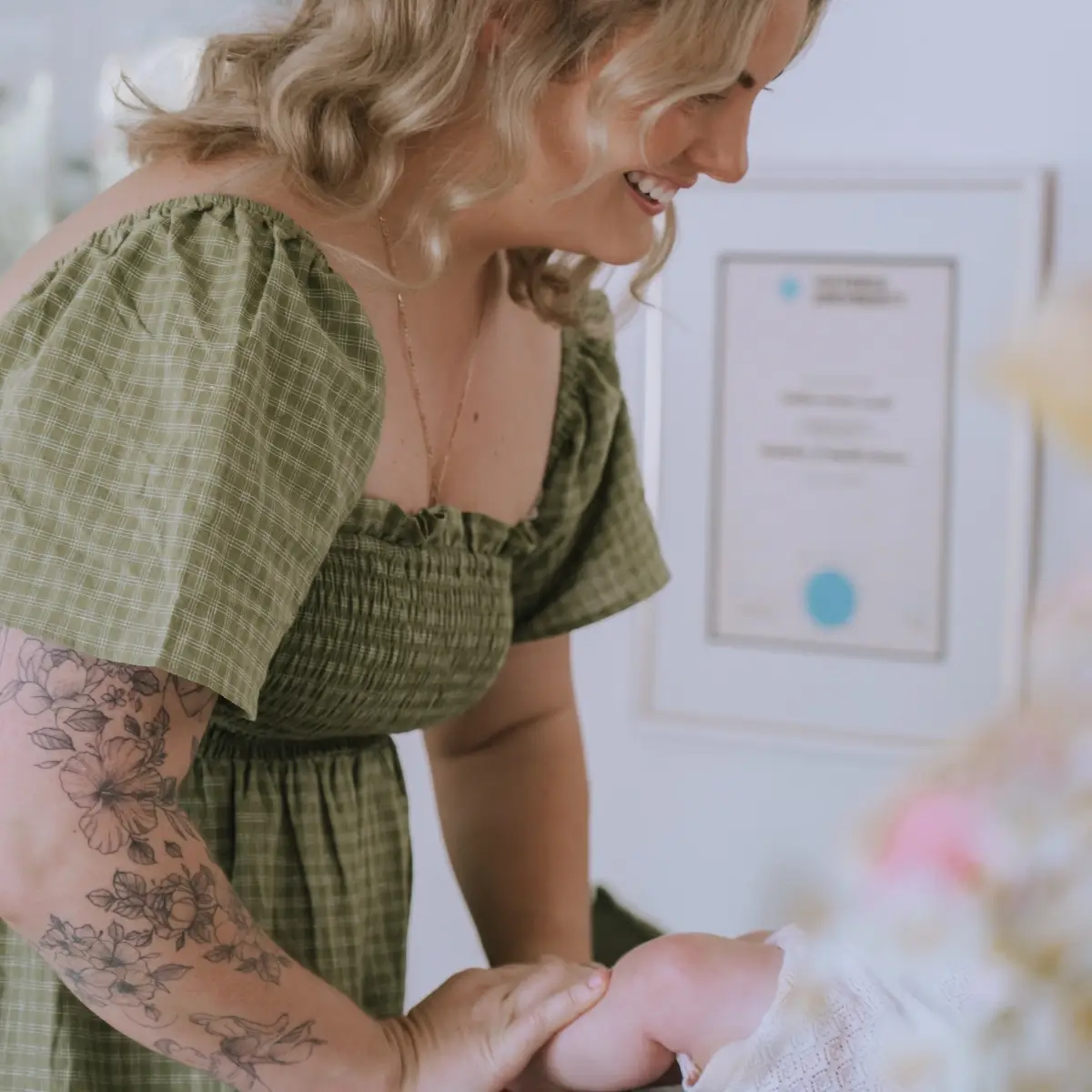 Close-up shot of Caitlin holding a baby lying down on a table