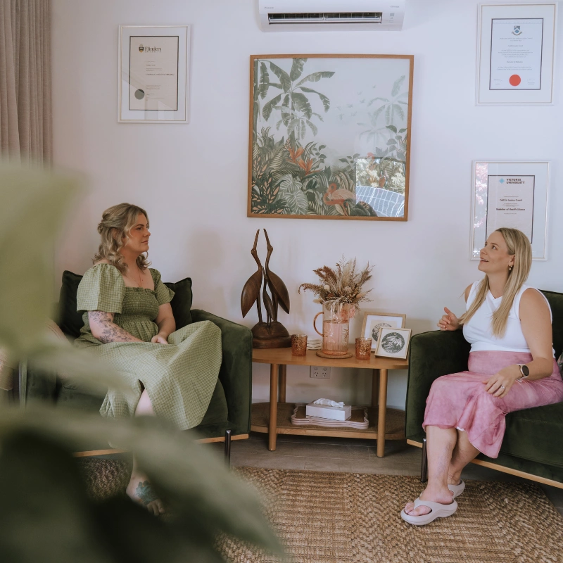 Photo of Caitlin talking with a client in a bright, comfortable clinic office