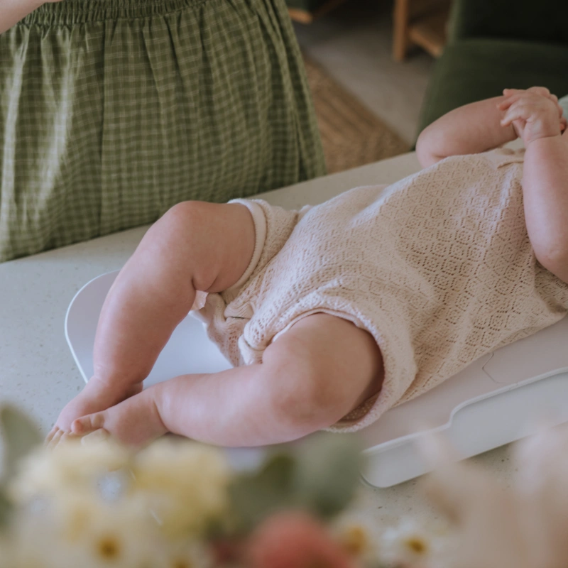Photo of a baby lying down while having a checkup with a midwife