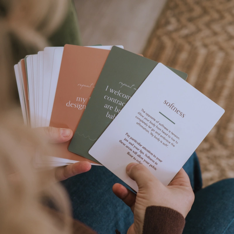 Close-up shot of Caitlin's hands holding several cards