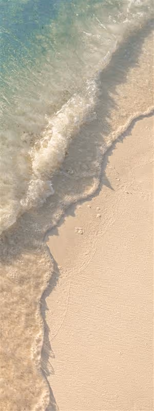 A white sandy beach with waves crashing on it.