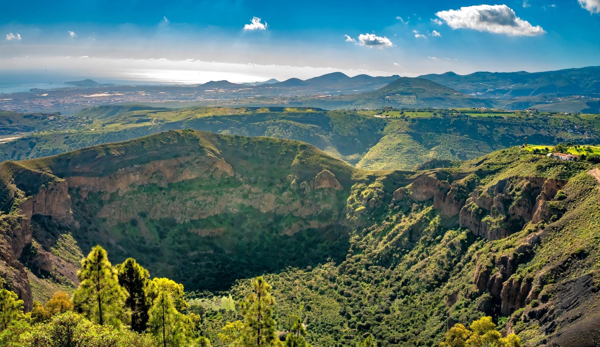 En Bandama, en la isla Gran Canaria, hay una vista aérea preciosa, donde se observa un gran crater y cerca un campo de golf 