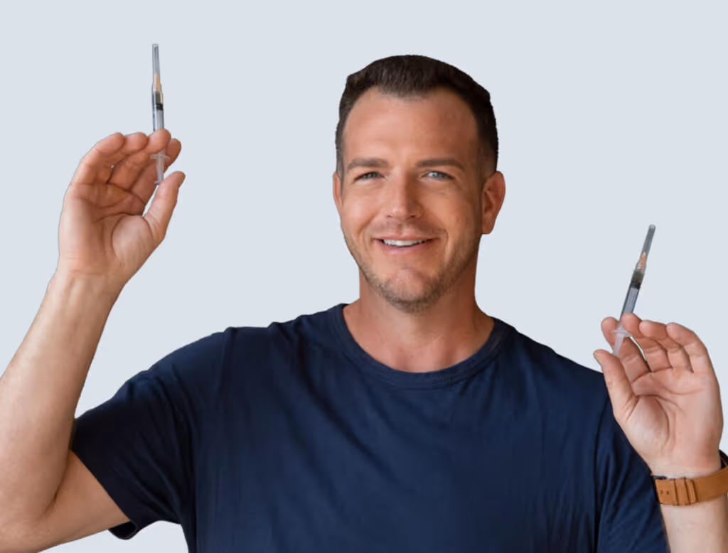 Supplements for Men on Hormone Therapy | Victory Men's Health | Man holding up testosterone injection and smiling