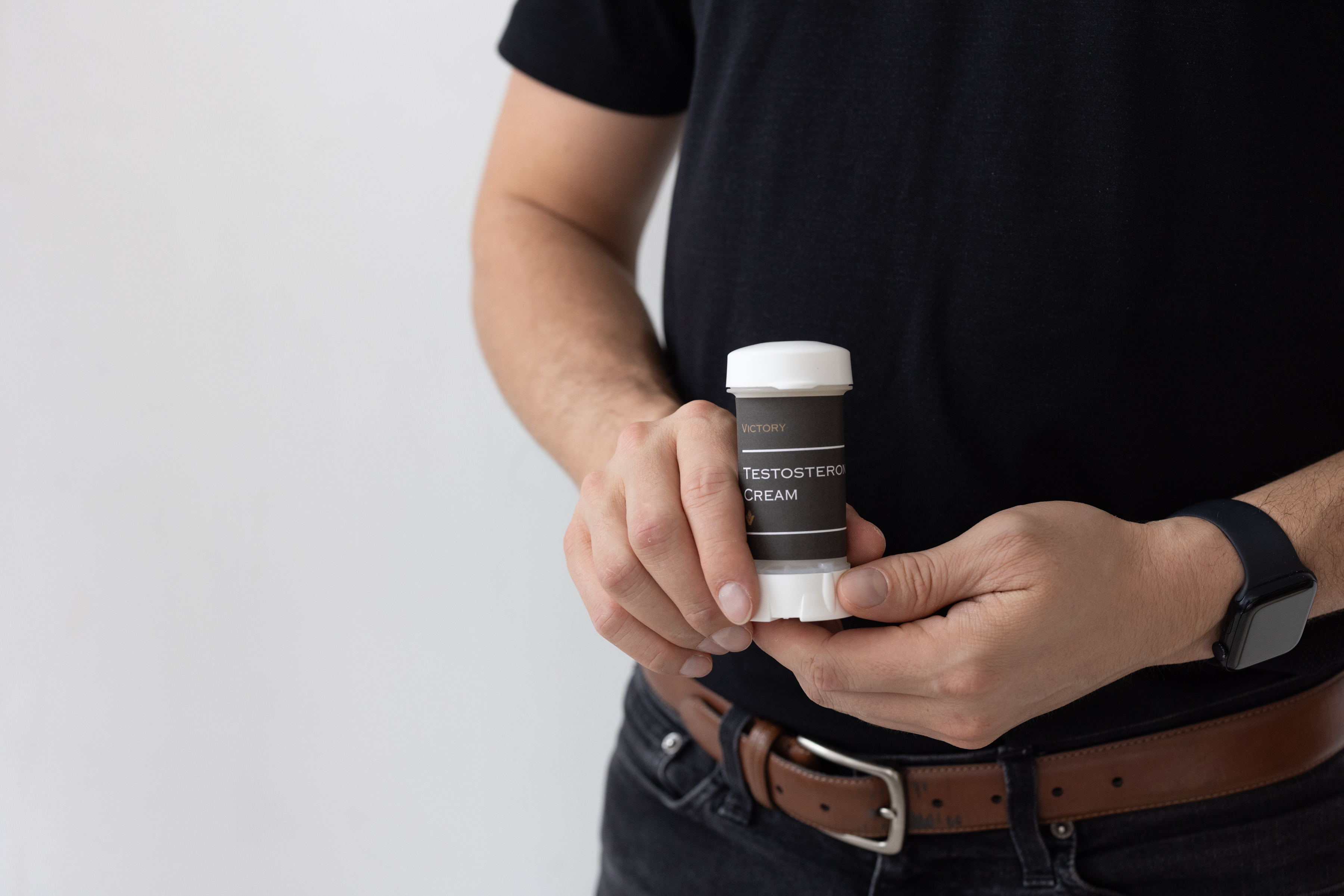 Man holding testosterone cream used for hormone therapy illustrating differences in absorption between standard gels and transcrotal application