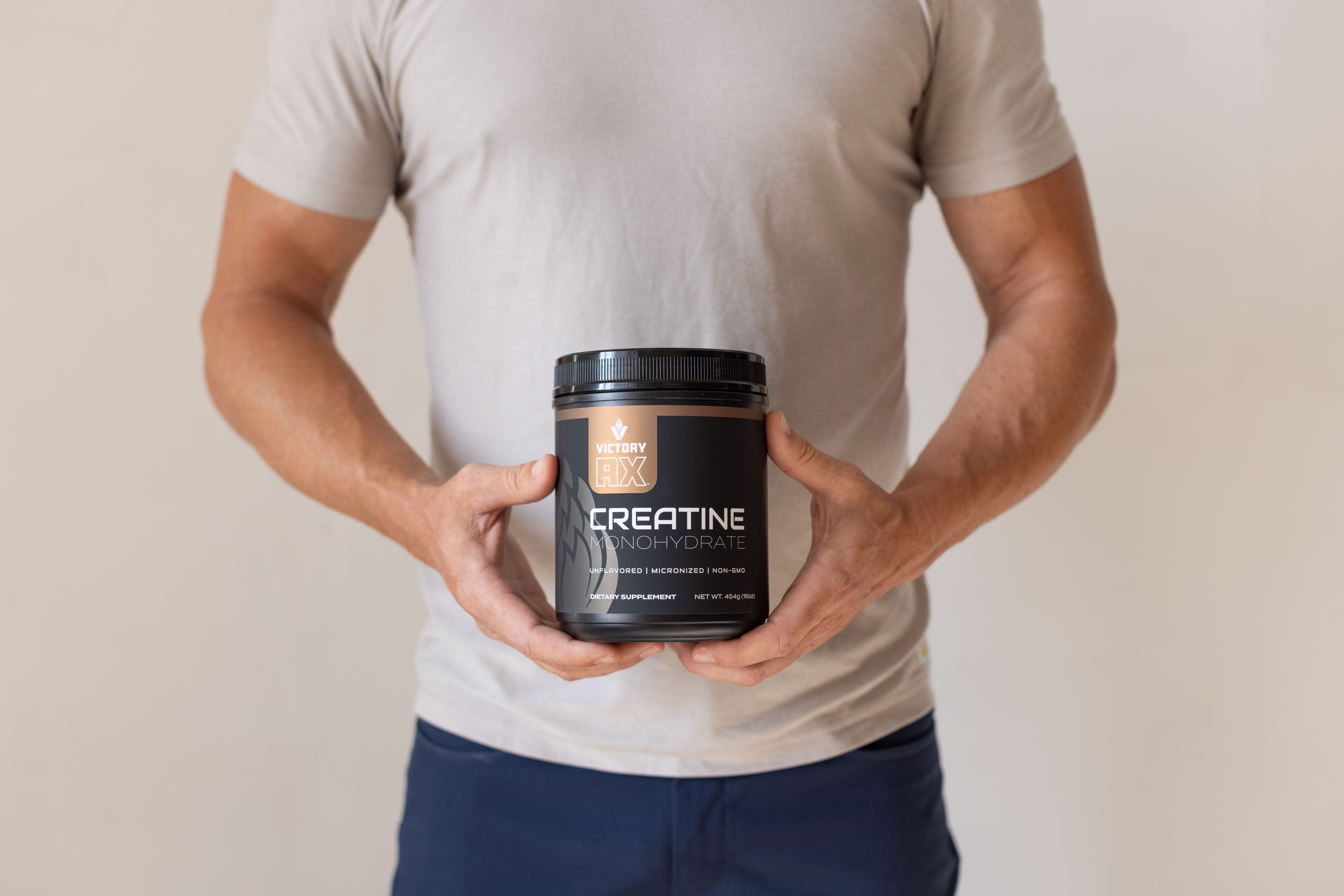 Man holding Victory RX creatine monohydrate supplement for muscle performance, brain health, and cognitive support.
