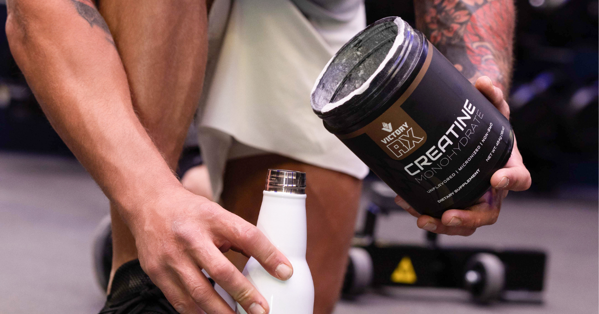 Fit man adding creatine monohydrate to his water bottle for muscle growth