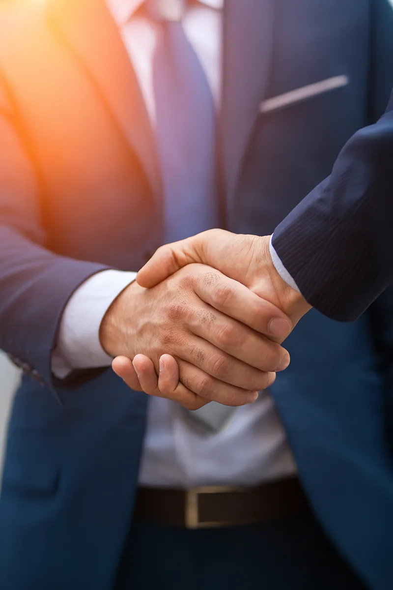 Apretón de manos representando acuerdo en intermediación estratégica corporativa
