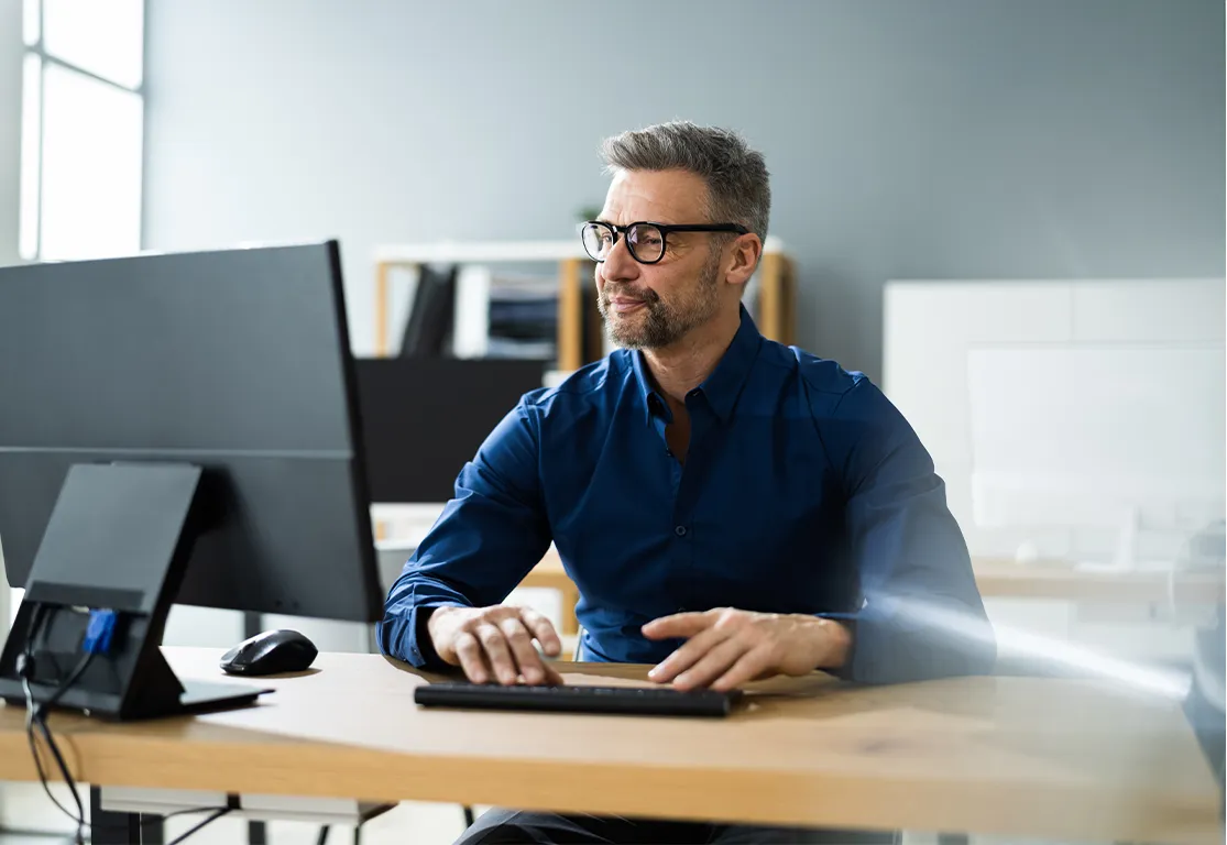 Executive working on a computer in a corporate strategic management environment
