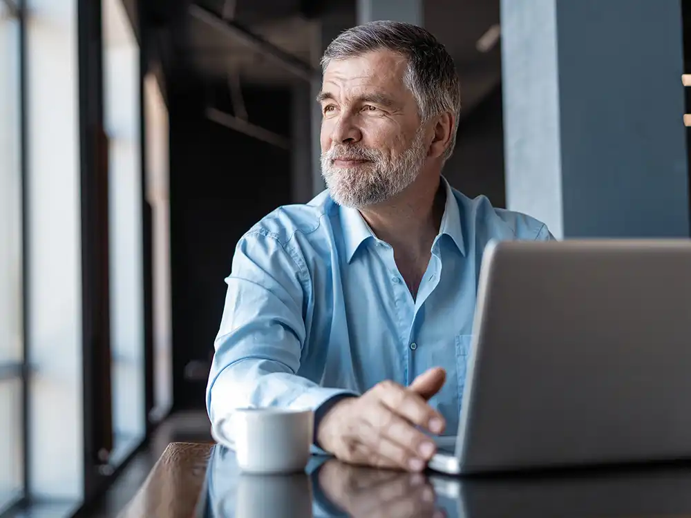 Ejecutivo con laptop en sesión de consultoría estratégica corporativa
