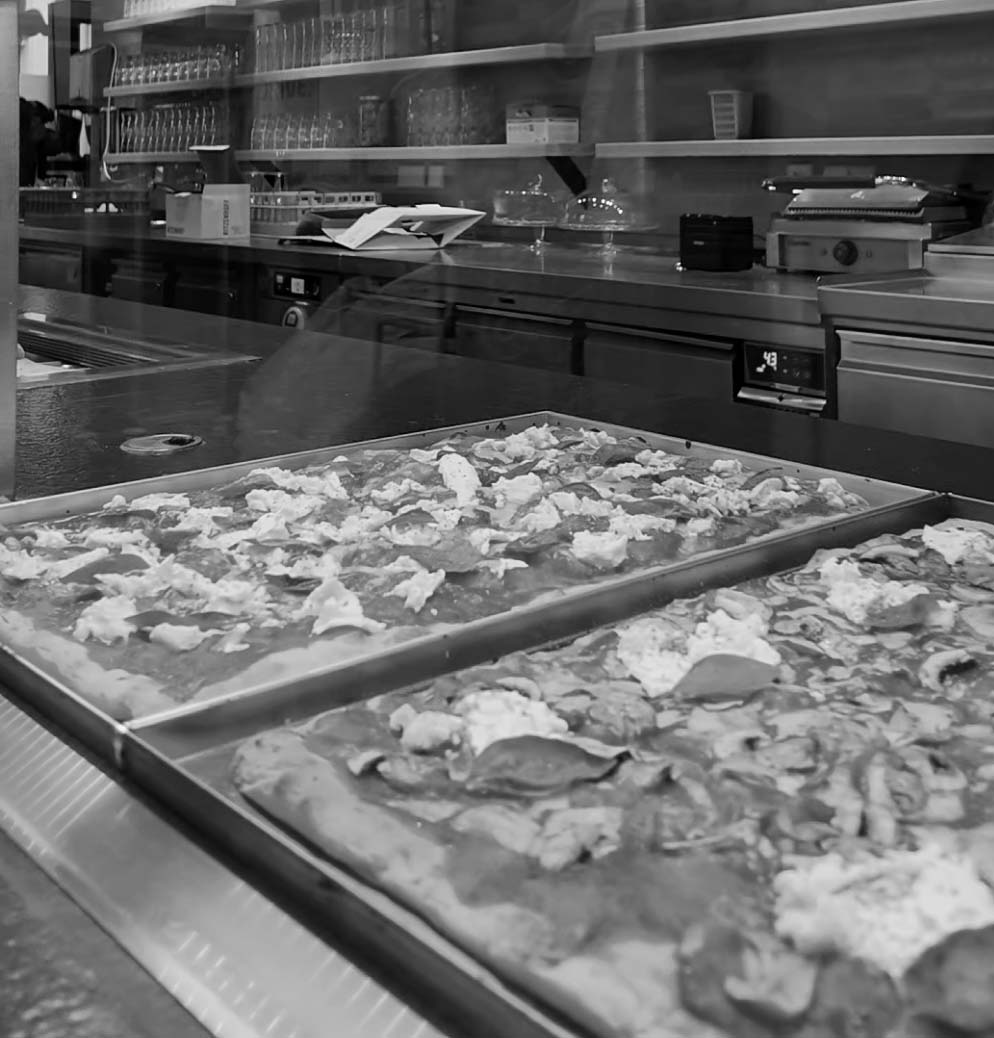 Chef placing cheese on raw pizza bread