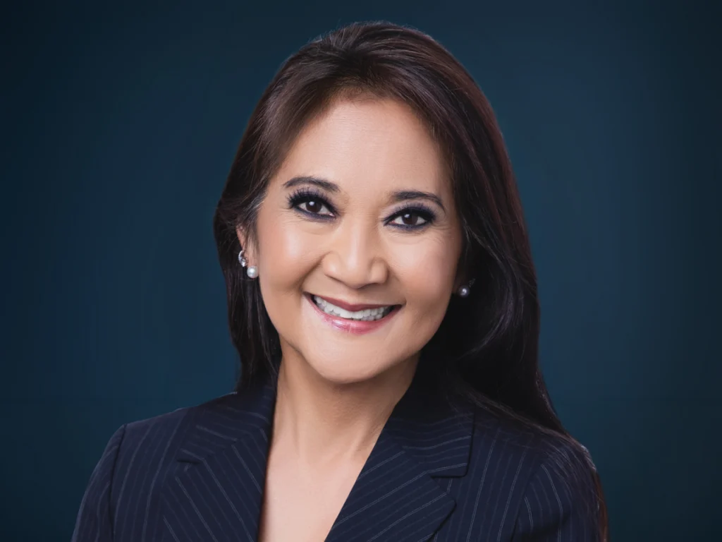 Dr. Iris Tam, Head of Medical Affairs, a smiling woman with long dark hair in a pinstriped navy blazer
