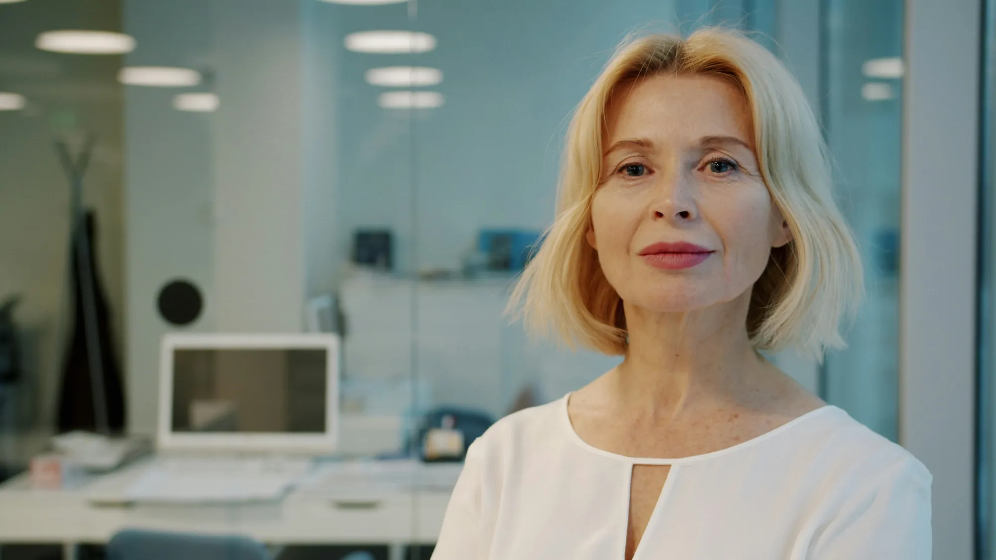 Selbstbewusste Frau mittleren modifie les cheveux blonds dans un bureau moderne