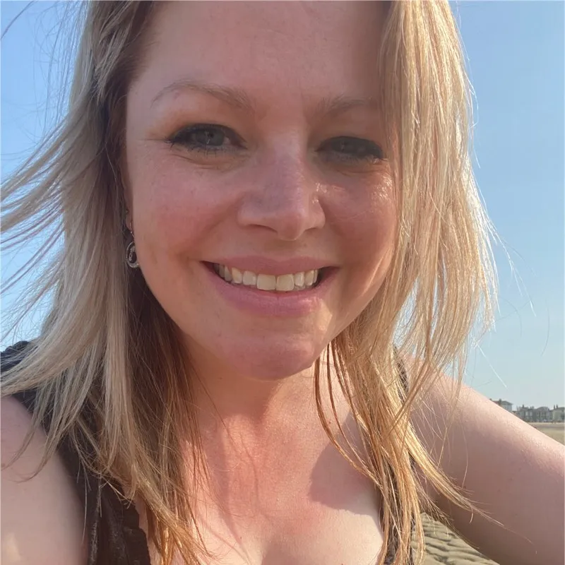Lächelnde blonde Frau im Freien an einem sonnigen Tag in Nahaufnahme