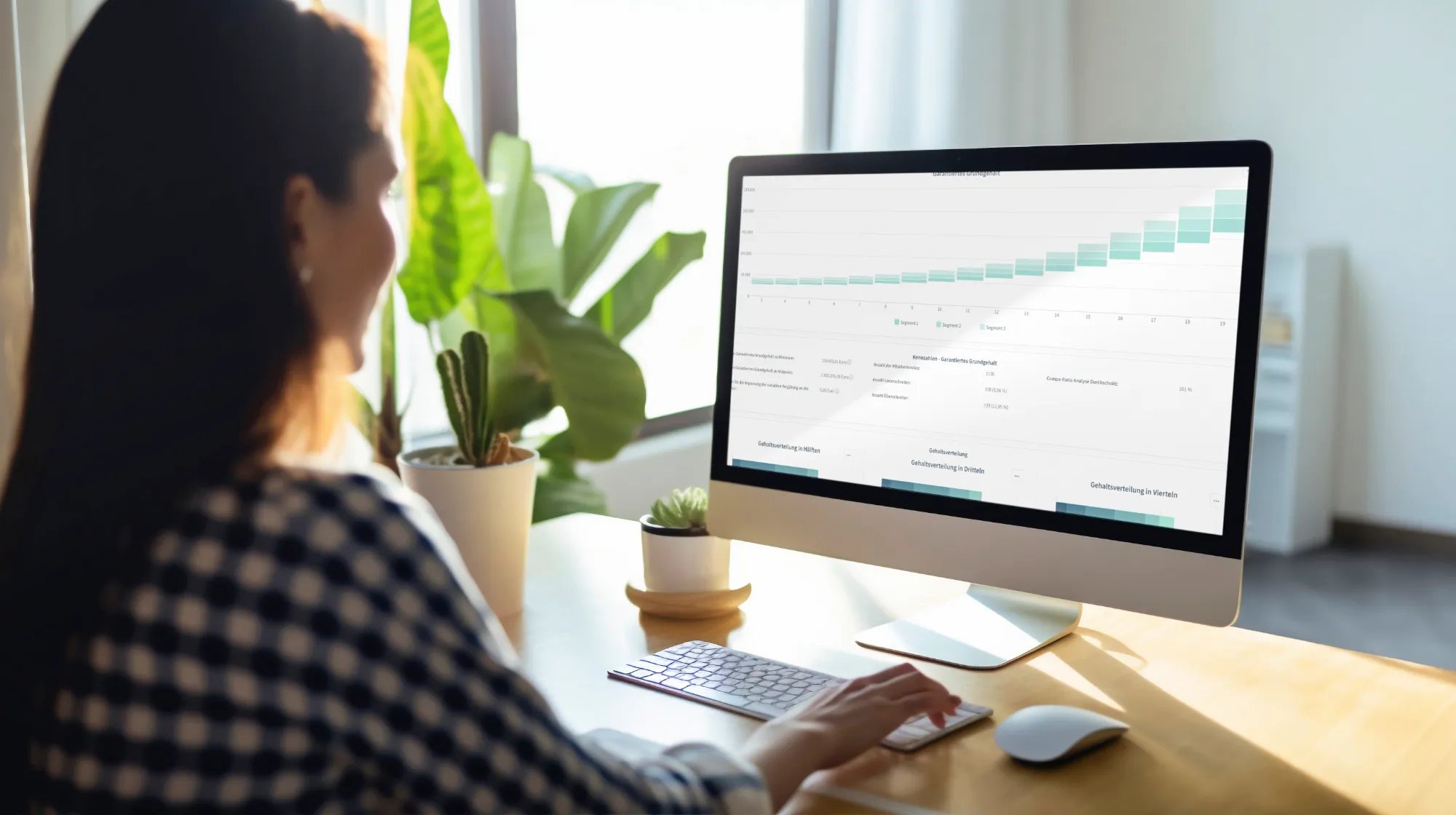 Une femme analyse des diagrammes et des tableaux de bord sur un ordinateur de bureau dans un bureau