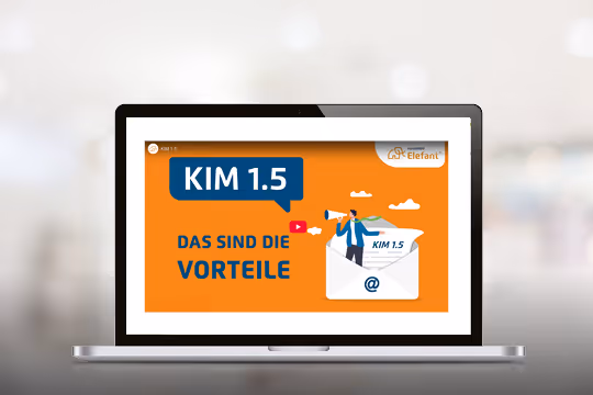 Laptop zeigt eine Folie mit dem Titel KIM 1.5 und dem Text Das sind die Vorteile, begleitet von einer Illustration eines Mannes, der aus einem großen Briefumschlag kommt.