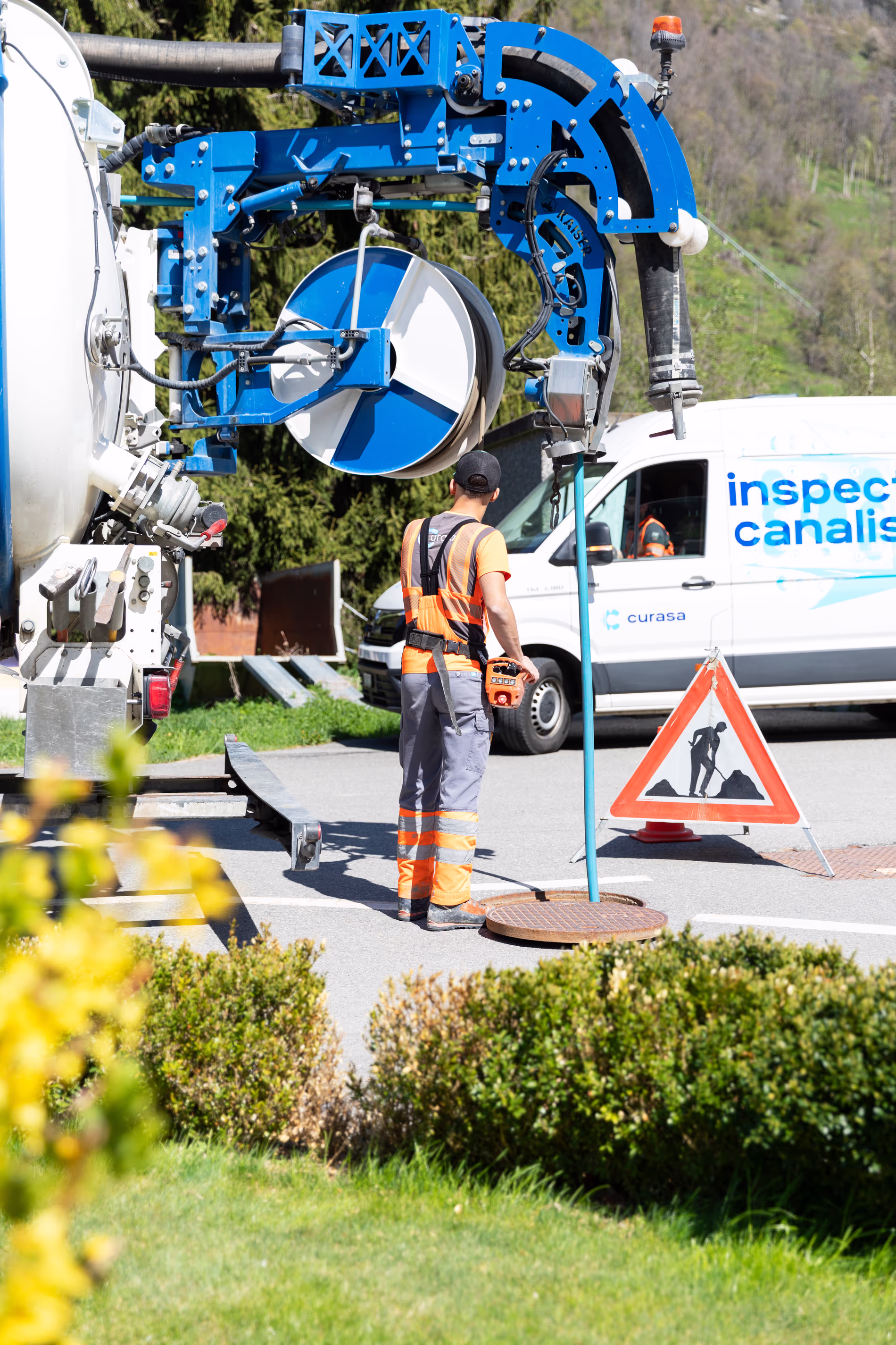 Un tube tombe dans une bouche d'égout sur une route depuis un camion.