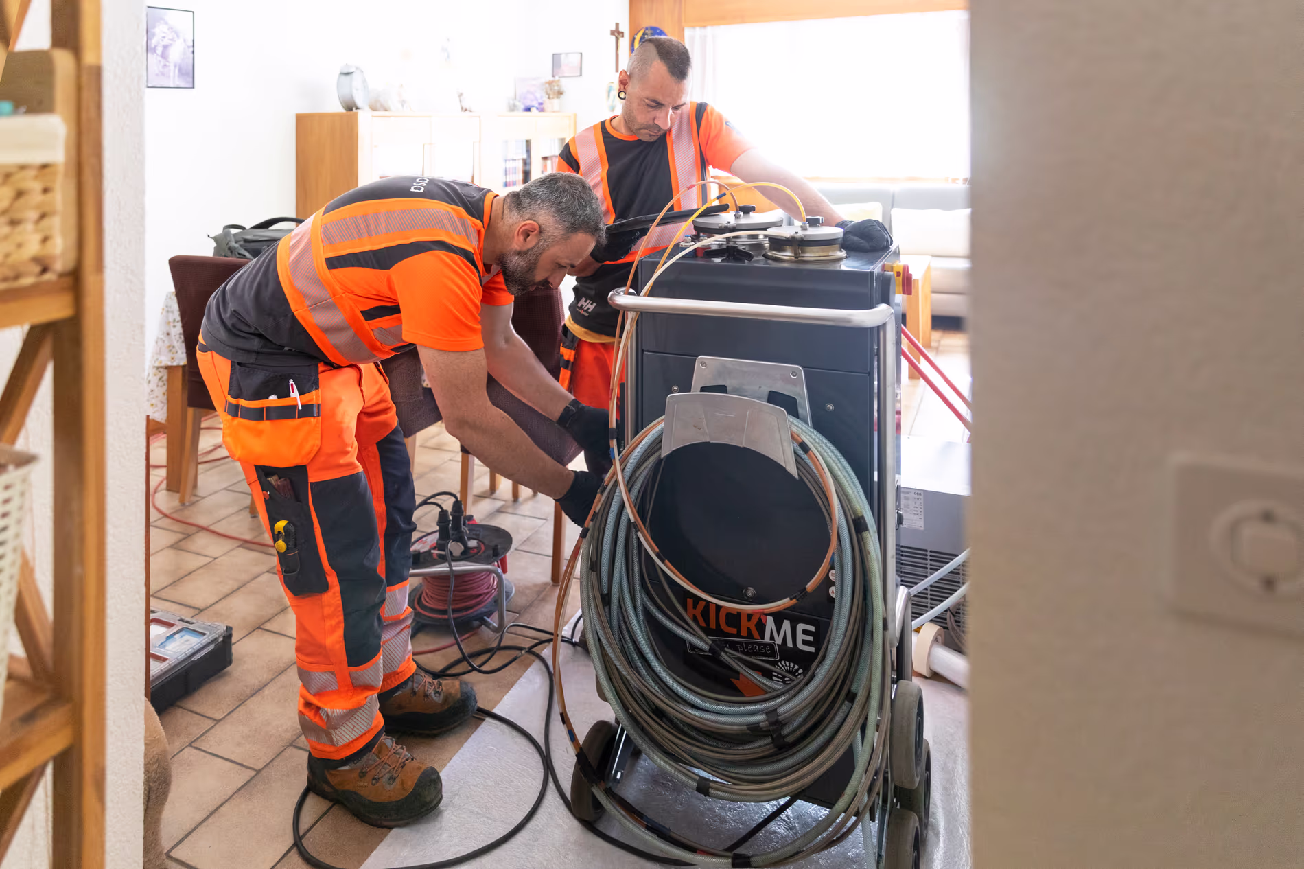 Deux employé en train de mettre en place une machine dans la cuisine d'un particulier.