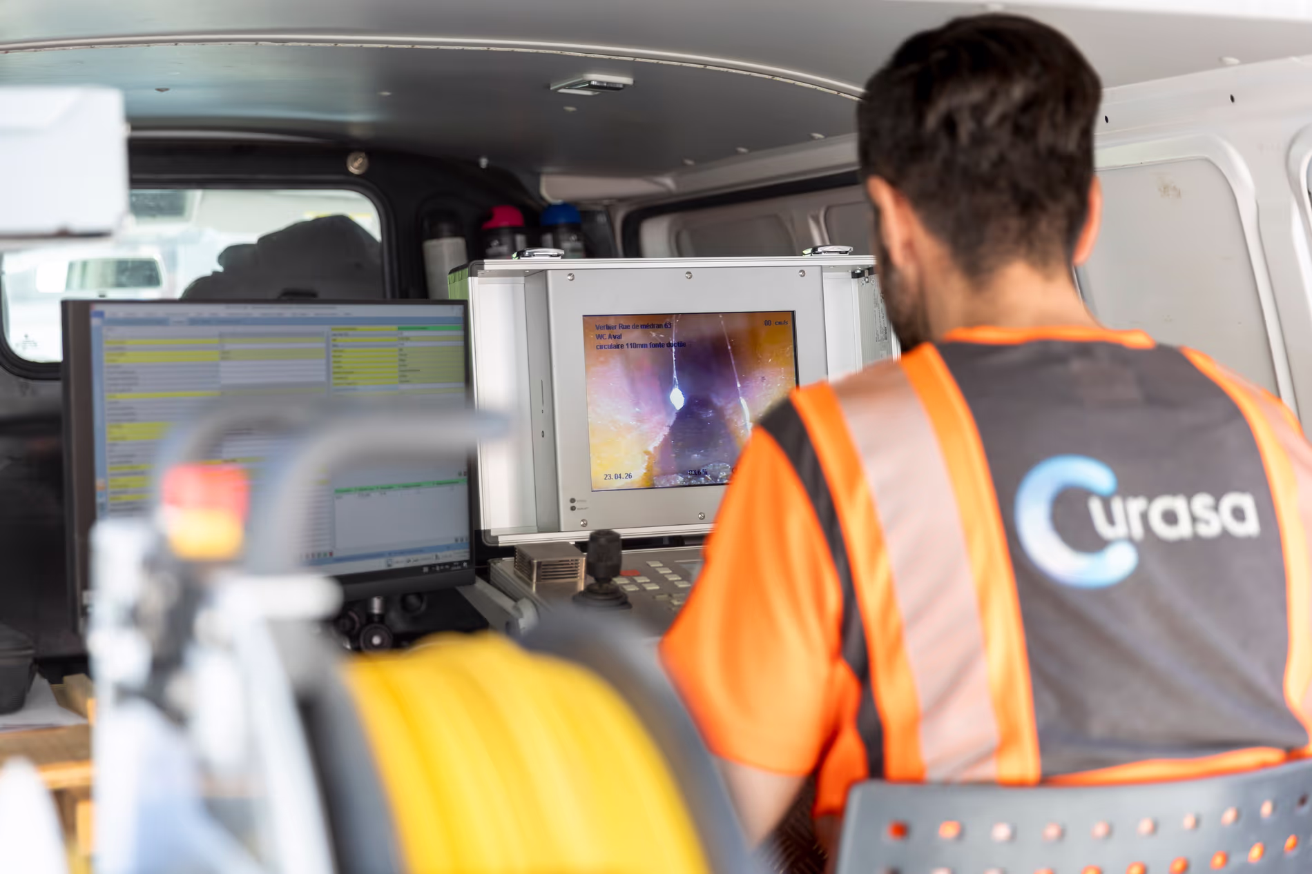 Un employé manipule un robot-caméra depuis sa camionnette sur l'ordinateur de bord.