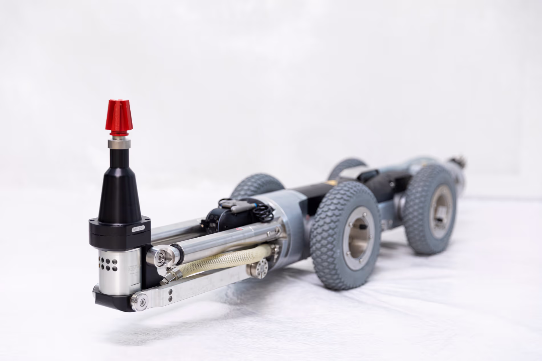 Un petit robot à quatre roue est équipé d'une fraiseuse à son avant.
