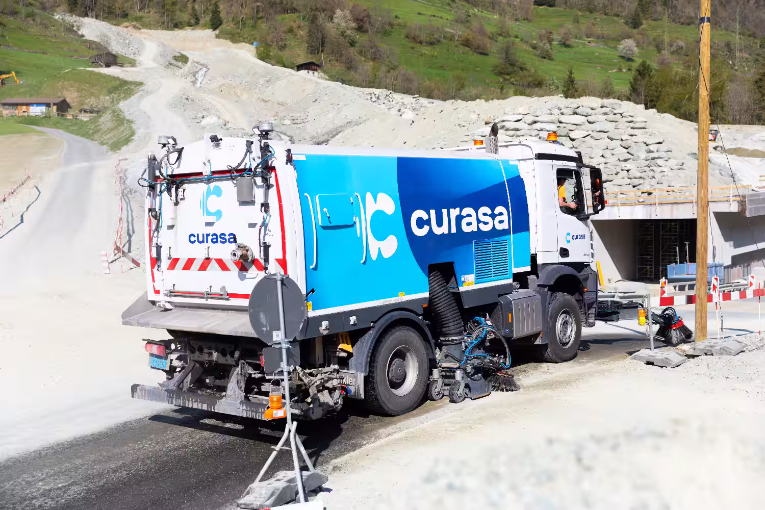 Un camion balayeuse sur une route de chantier