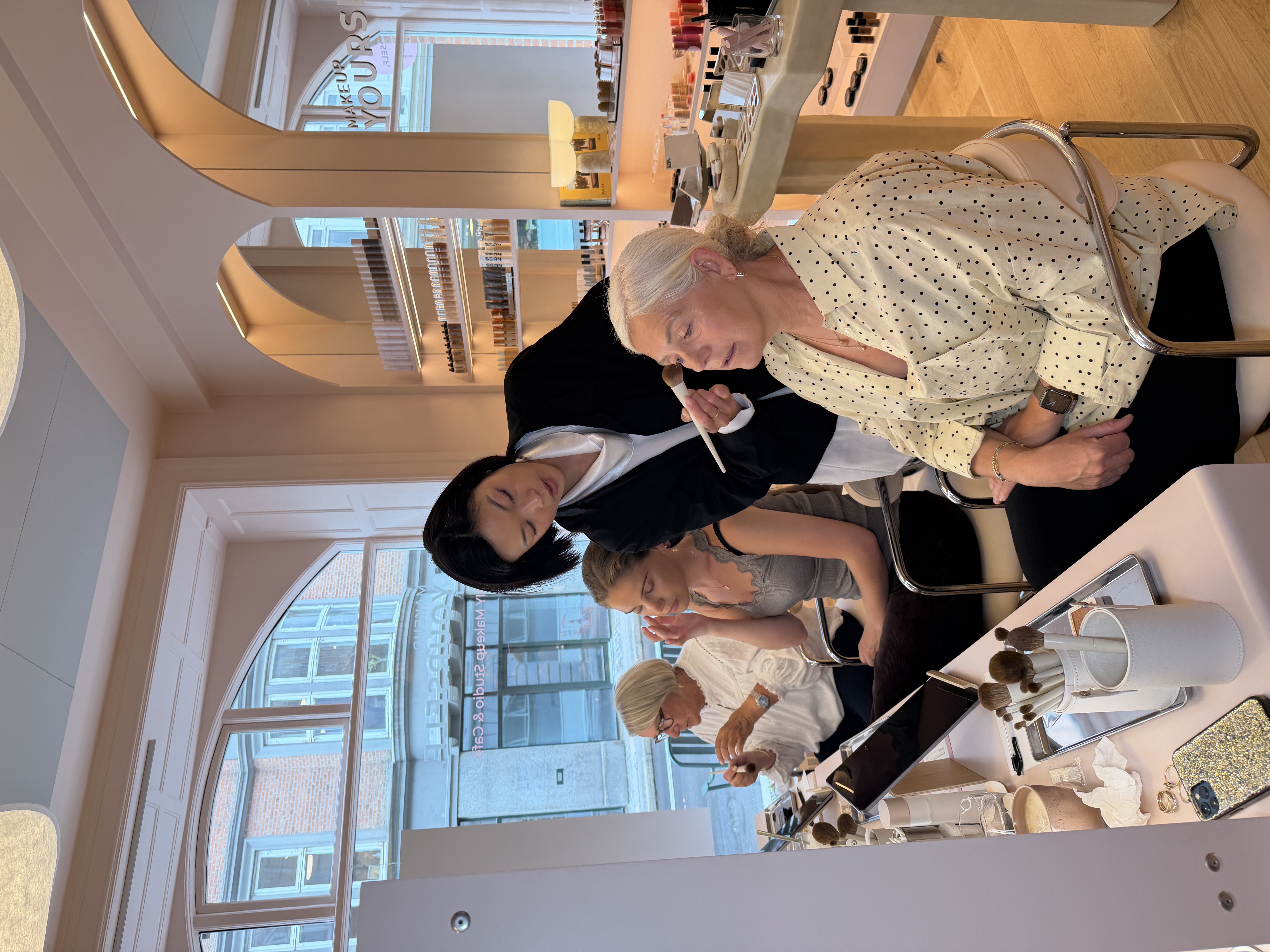 Professional photoshoot team with eight people in a studio, surrounded by lighting equipment, in a relaxed and cheerful atmosphere.