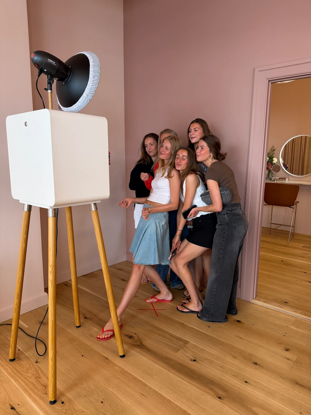 Professional photoshoot team with eight people in a studio, surrounded by lighting equipment, in a relaxed and cheerful atmosphere.