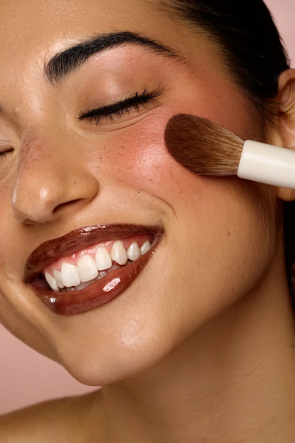 Kvinde med lyst krøllet hår lægger lipgloss