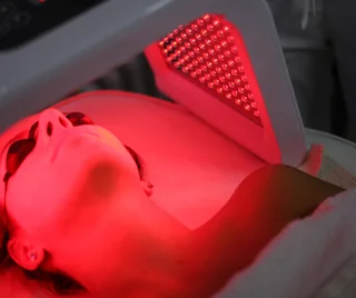 Client under a red Celluma LED panel