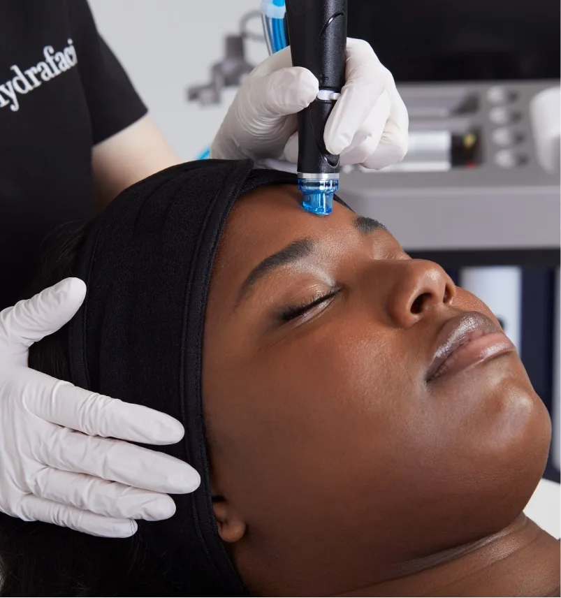 HydraFacial handpiece on a client's forehead
