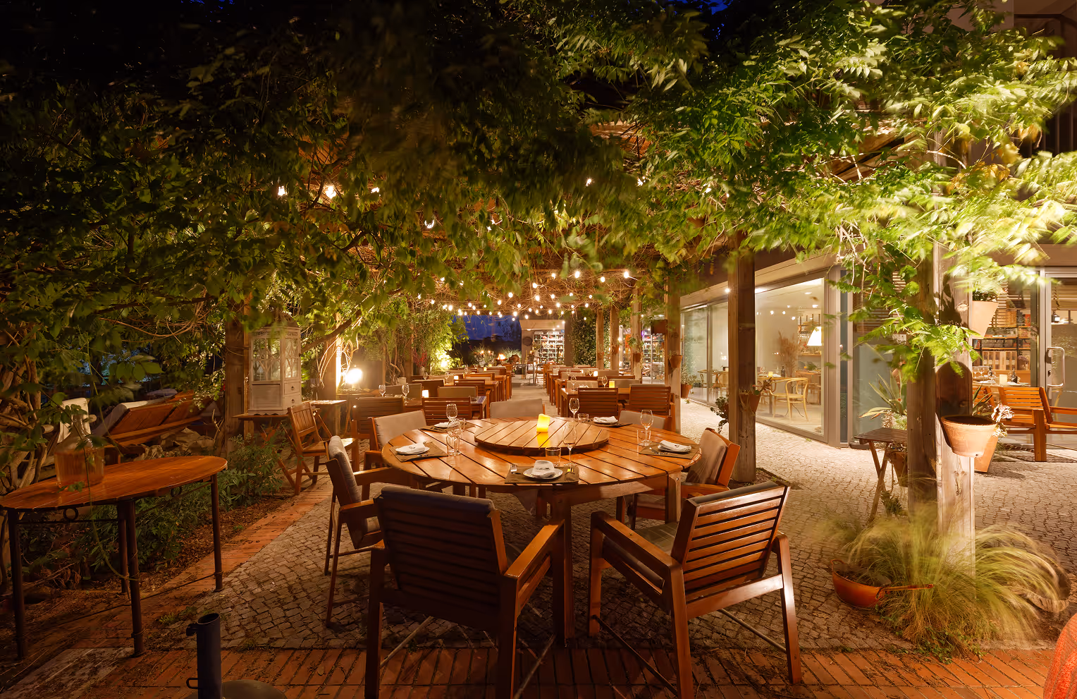 Outdoor restaurant terrace at Hotel Vale do Gaio under festoon lights in the evening