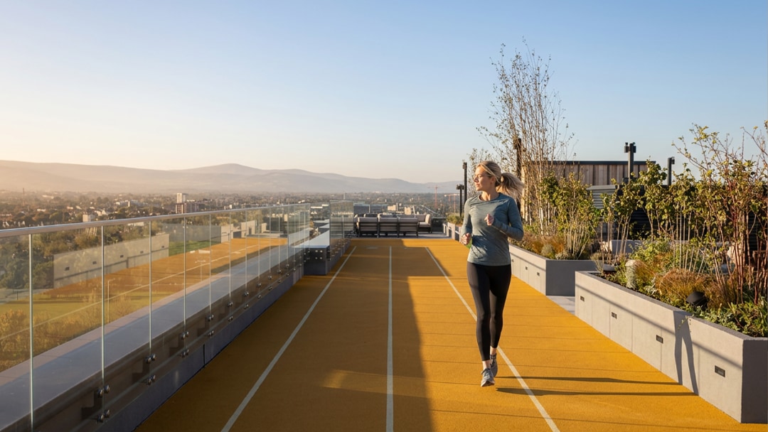 Two runners on a path through the landscaped parkland at Glass Bottle, Dublin, with the new blocks behind