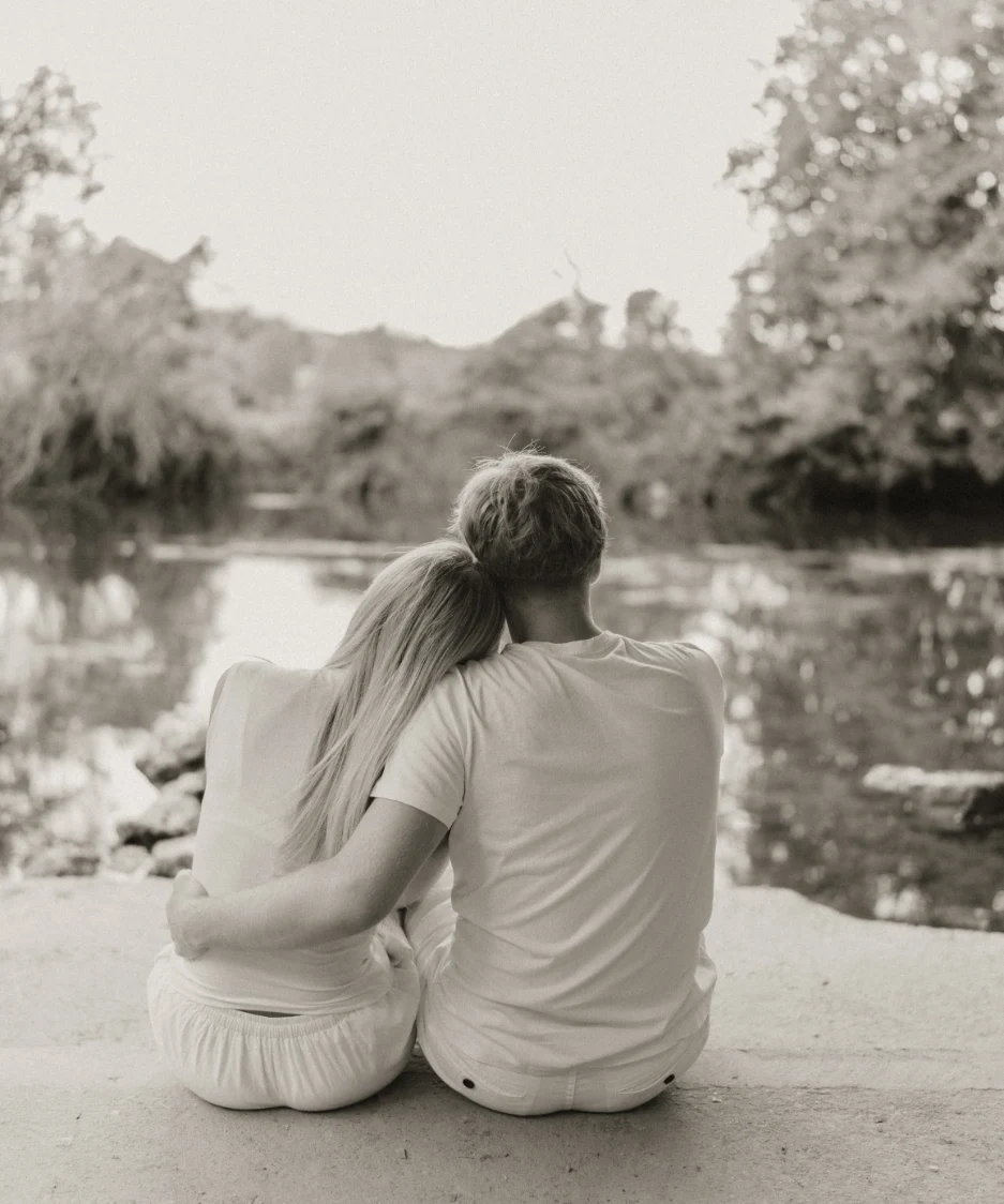 Image d'un jeune couple d'amoureux de dos regardant un lac 