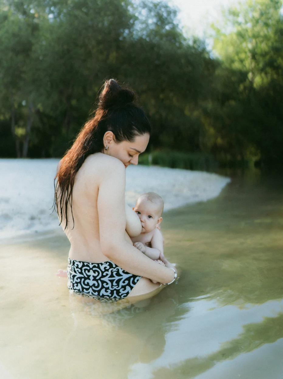 Maman qui donne le sein à son bébé au bord d'un lac en dordogne