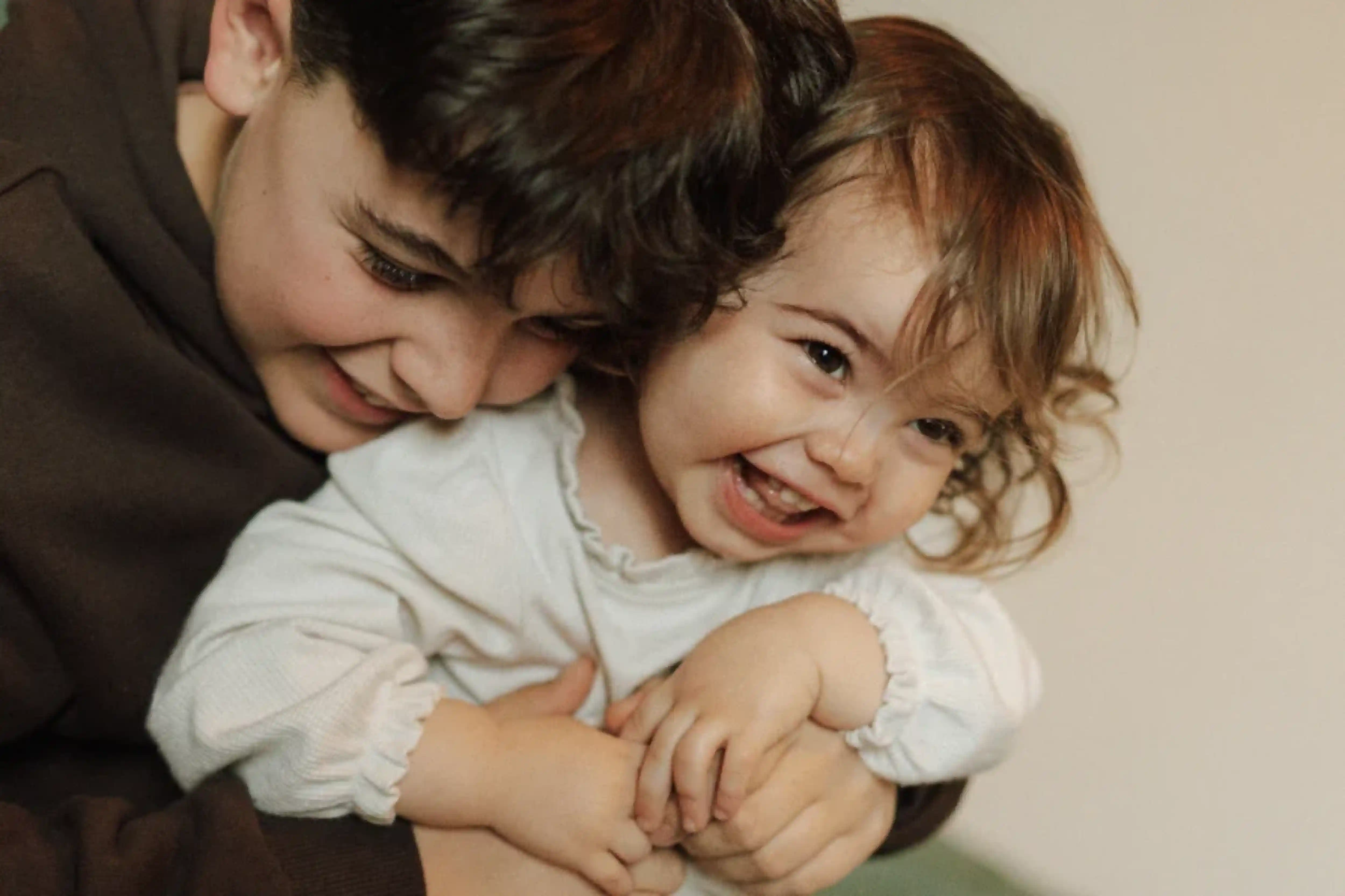 Image d'un frère et d'une petite soeur s'enlaçant
