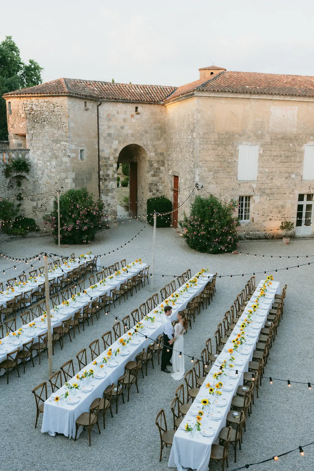Image des mariés sous le voile de la mariée, le mari donne un baiser sur le front de sa femme 