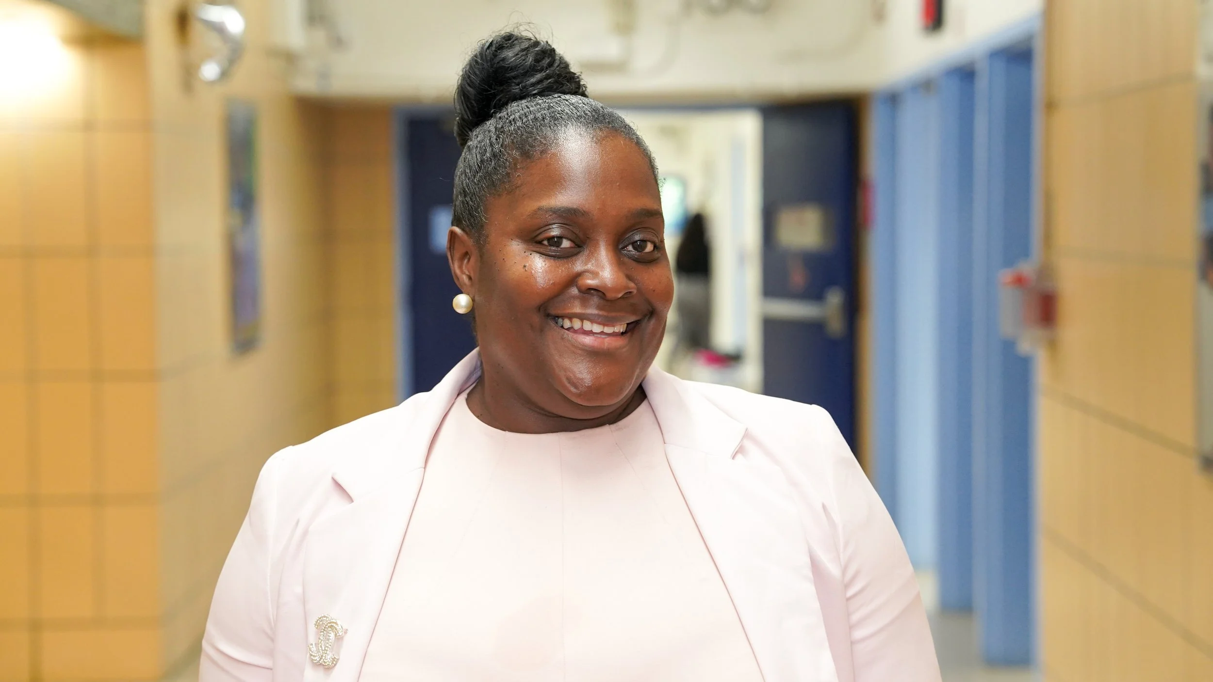 Katisha Thompson smiling in a school hallway