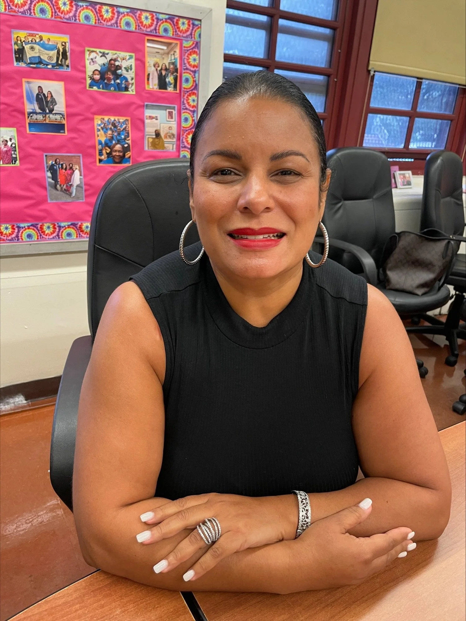 Ana De Jesus smiling at her desk in a school office