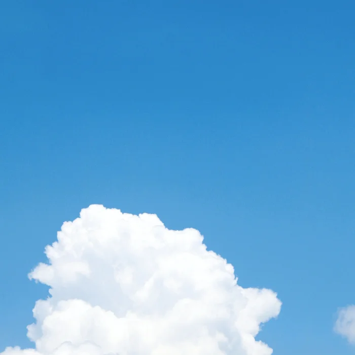 Fluffy white clouds against a clear blue sky.